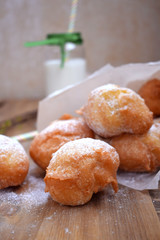 French doughnuts Beignet covered with sugar powder on a wooden table