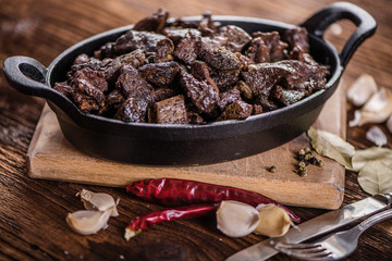 braised beef and lamb meat, liver, lungs and heart dish in black iron cast heavy dish