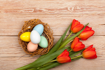 Easter Eggs in a birds nest with colorful tulips