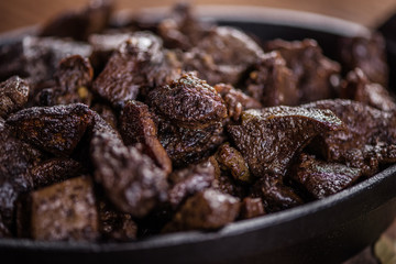 braised beef and lamb meat, liver, lungs and heart dish in black iron cast heavy dish