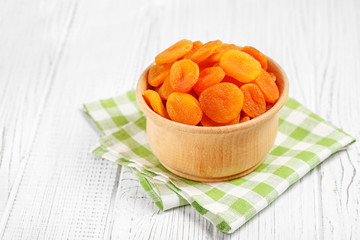 Dried apricots in a wooden bowl. The concept is healthy food, vegetarianism, diet, vitamins.
