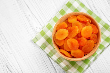 Dried apricots in a wooden bowl. Top view. The concept is healthy food, vegetarianism, diet, vitamins.