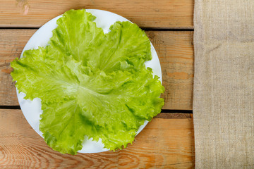 on a wooden table is the lettuce leaves in a plate for cooking vegetable salad