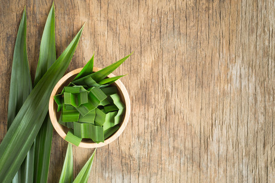Fresh green pandan in a wooden bowl on wood table,pandan leaves on old wood background,top view and copy space