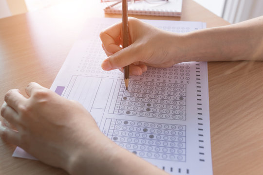 Selective focus Student filling out answers to a test with a pencil.