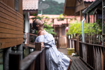 beautiful girl standing on the pier in fisherman's Cove, the color of Thai village