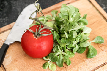 Feldsalat und Tomate auf dem Schneidebrett