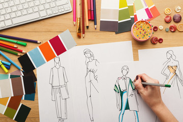 Top view on woman designer drawing clothes sketches