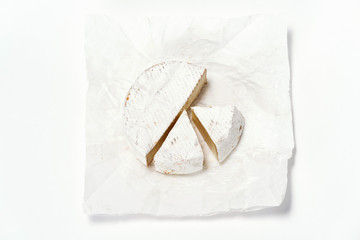 Cheese camembert or brie sliced on white background. Menu design restaurant. Top view design photo. Cheese in white paper. Overhead. Flat view horizontal photo.