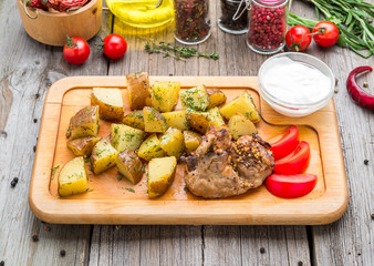 Roasted whole chicken with potatoes and thyme in a cast iron skillet