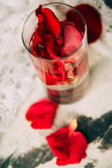 glass delicious refreshing drink of rose petal flower on blue wooden background, infusioned water