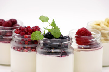 Fresh berries in the jar with the yogurt. On white background.