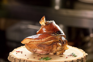 Oiled pork knuckle on the stamp table. Oiled tasty pork knuckle on the stamp with side dish.