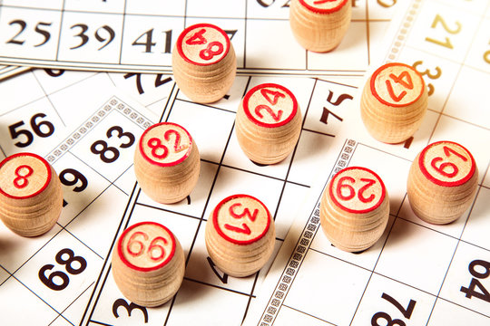Bingo or lotto game. Wooden kegs of lotto on cards. Top view.