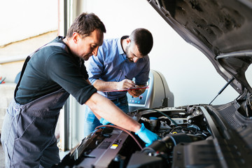 Fototapeta na wymiar Auto mechanics repairing car. 