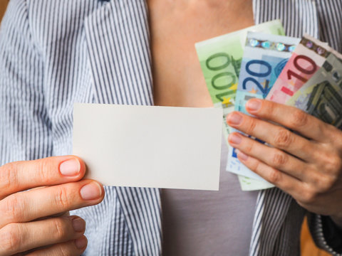 Business card on the background of Euro banknotes in the hands of a business woman