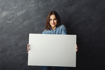 Young woman holding blank white banner