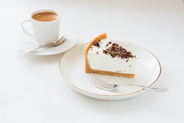Homemade Cheesecake with chocolate and a cup of coffee on a white background.