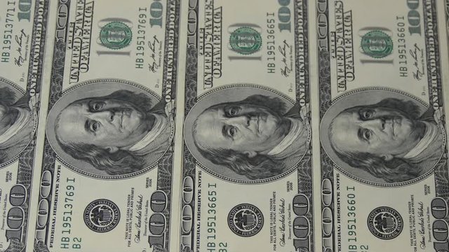 Hundred dollar bills in a row. Motion camera slider. Macro photography of banknotes. Portrait of Benjamin Franklin.