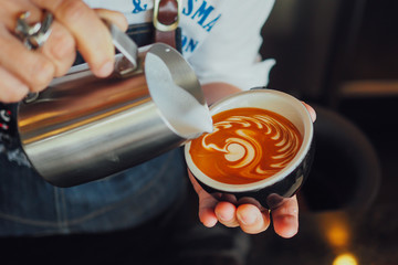 barista make coffee latte art with coffee espresso machine in coffee shop cafe in vintage color tone