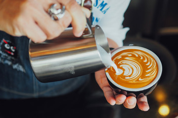 barista make coffee latte art with coffee espresso machine in coffee shop cafe in vintage color tone