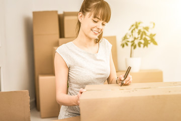 Young woman signs a box while moving.