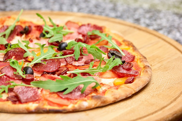 Close-up view on delicious pizza. Appetizing pizza on wooden board, close up.