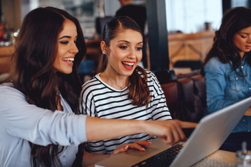 Two women using laptop in a coffee shop