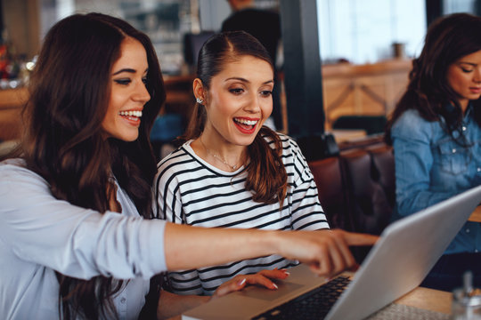 Two Women Using Laptop In A Coffee Shop