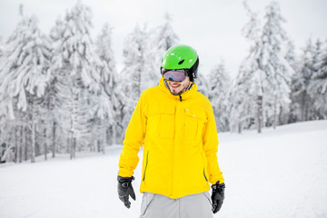 Fototapeta na wymiar Portrait of a snowboarder in colorful winter sports clothes outdoors at the snowy mountains