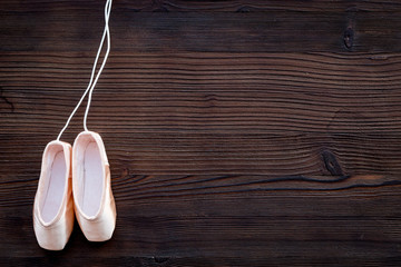 Ballet pointe shoes on dark wooden background top view copy space