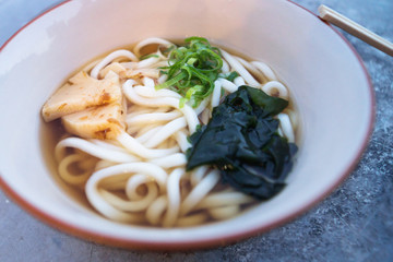 Bowl with japanese Ramen with Udon noodles, bamboo and spring onions with chopsticks