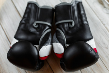 Pair of leather boxing gloves on wooden background. Sport equipment