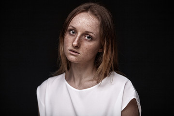 closeup studio portrait of freckled woman without makeup