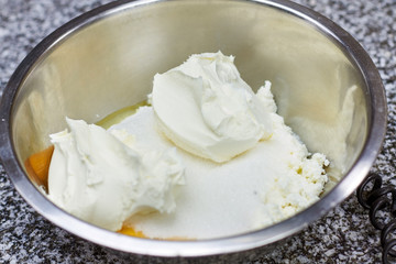 Sour cream and sugar in a bowl. Ingredients in a mixing bowl are ready to be mixed. Uncooked sauce ingredients.