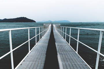 Obraz premium White boat jetty reaching into the dark blue sea, Naoshima, Japan