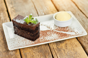 Rain of flour on cake. Black belgian cake flouring with white powder.