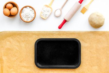Prepare to baking. Dough ball near cookware on white background top view. Mock up with baking paper