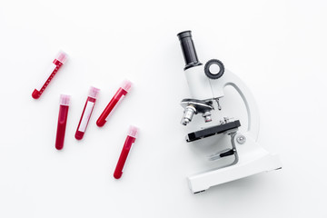 Blood test concept. Blood samples near microscope on white background top view
