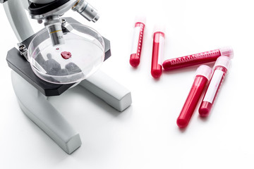 Blood test concept. Blood samples near microscope on white background top view close up
