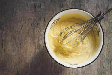 Preparation of raw sweet dough - egg, flour, sugar, vanilla mix in a bowl with a whisk
