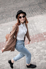 Active happy  young woman walking in the city