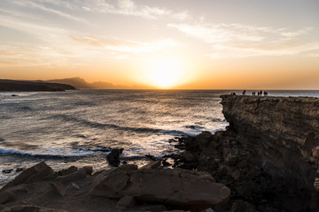 Fototapeta premium La Pared beach at sunset with people on top of the cliff in Fuerteventura, Canary Islands