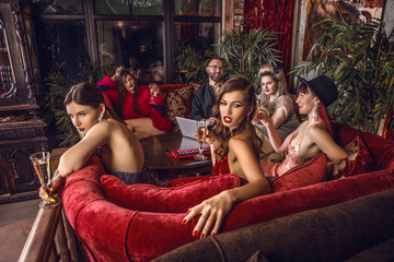 Group of young stylish people dressed classical style in interior of luxury club. - 189987962