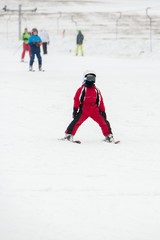 Fototapeta na wymiar Small boy in ski mask and helmet learns skiing