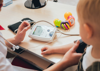 Doctor measuring blood pressure of a child.