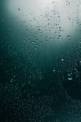 Bubbles of water on a shaded surface, blue background
