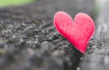 Fototapeta premium Close up view of a red heart on a rustic, old wooden background. Vintage toned. Love, romance or Happy Valentine's Day concept
