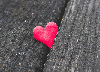 Fototapeta premium Close up view of a red heart on a rustic, old wooden background. Vintage toned. Love, romance or Happy Valentine's Day concept
