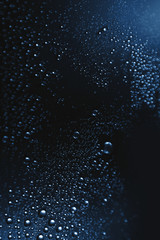 Bubbles of water on a shaded surface, blue background